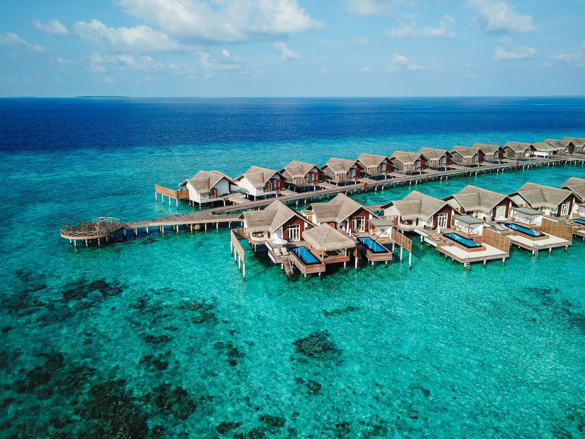 Maldives Water Villa Bungalow Overwater with Pool and step ladder to reach turquoise lagoon for swimming at luxury resort